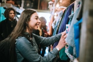 Woman wearing backpack shops through a secondhand store