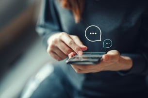 Women's hand typing on smartphone