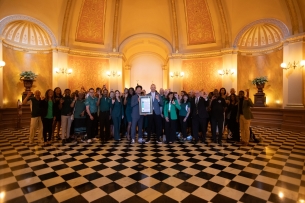 California state lawmakers and Sacramento State leaders smile for a photo in the state Capitol. 