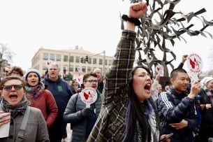 A photograph of demonstrating Boston University graduate student workers, one with their fist in the air.