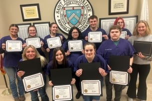 A group of veterinary assistant program students at Saint Joseph's College pose with their certificates.