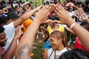 Virginia State University students hold up their hands and dance at Yard Fest.