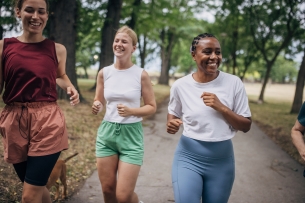 Diverse group of women jogging together on a summer day in public park