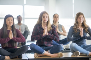 A group of students meditate in class