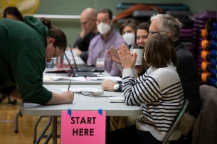 An individual signs in to vote at Michigan State University