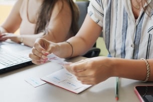 Two unidentified students study before class using flash cards