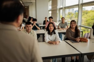 View of the back of the head of an instructor lecturing a diverse classroom 