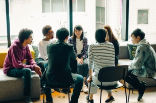 Young men and women discussing at a café.