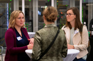 A Scripps Research alumna networking with two trainees