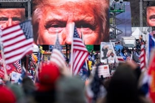 Large images of former president Trump's face on video screens loomed over a crowd of his supporters, many bearing American flags, as they gathered at the White House on Jan. 6, 2021.