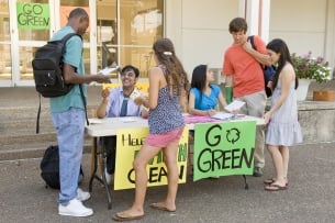 A group of students discusses climate change and sustainability on a college campus.