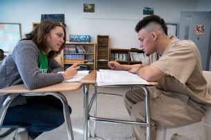 A Petey Greene tutor works with an incarcerated student in a classroom