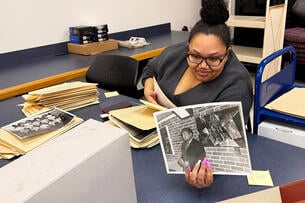An archivist holds up a photograph.