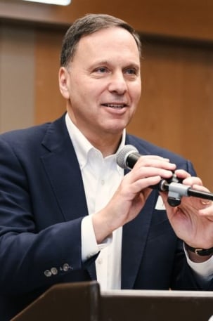 Ronald Liebowitz stands at a podium with a microphone