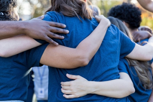 Students are shown hugging in a circle