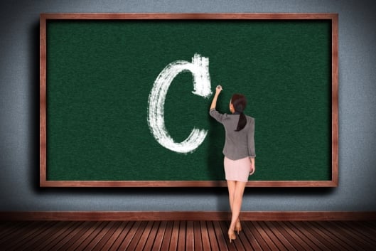 Teacher writes a big C on a blackboard