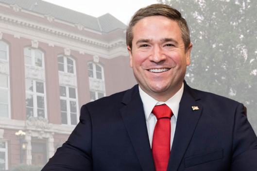 Andrew Bailey, a white man wearing a business suit and red tie