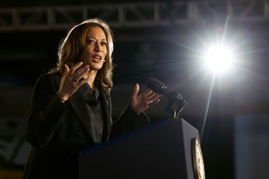 Kamala Harris gestures in front of a podium. 