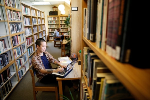 A student studies in the library at Naropa University