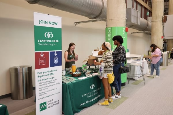 Students at an information table in a while hallway