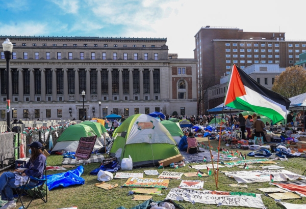 Pro-Palestinian protestors camp on the lawn outside Columbia University's stately Butler Library. Tents, sign and a Palestinian flag are all prominent in the photo.