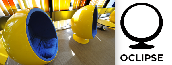 Two yellow spheres with holes cut out to reveal a blue interior where a person may sit. 