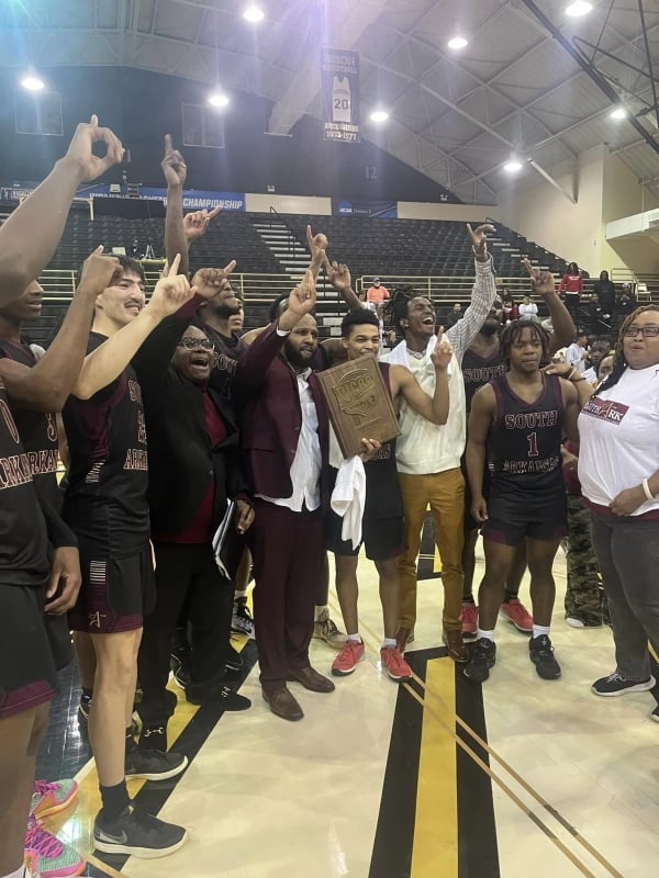Members of the South Arkansas College basketball team hold up one finger, signaling their conference title win