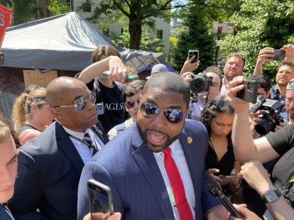 Rep. Byron Reynolds walks through protesters at George Washington University