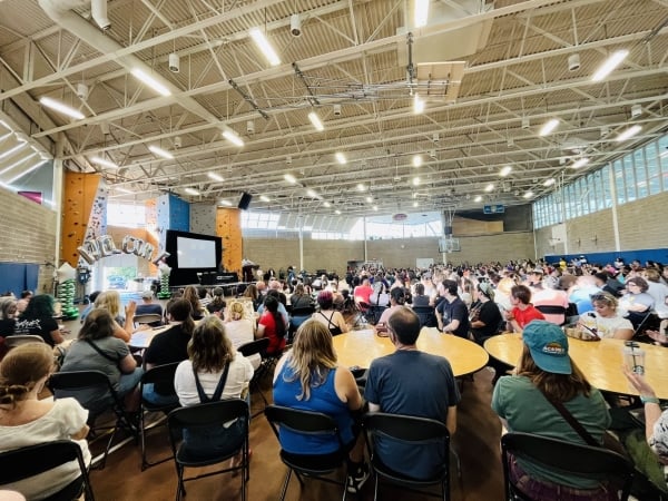 People sit at tables in an auditorium