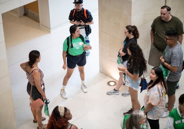 UNT transfer students and prospective students, wearing green T-shirts, walk around campus
