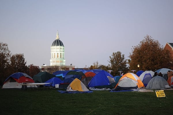 Camping tents on a green quad at dawn
