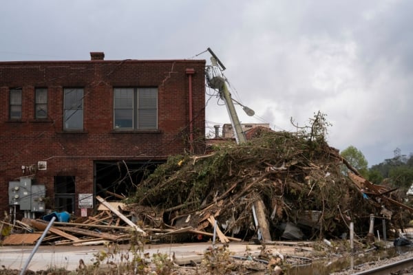 Storm debris piles up near in a brick building in Asheville