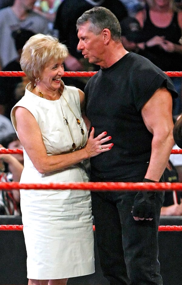 Linda McMahon stands in a white dress next to her husband, Vince, who is wearing a black shirt