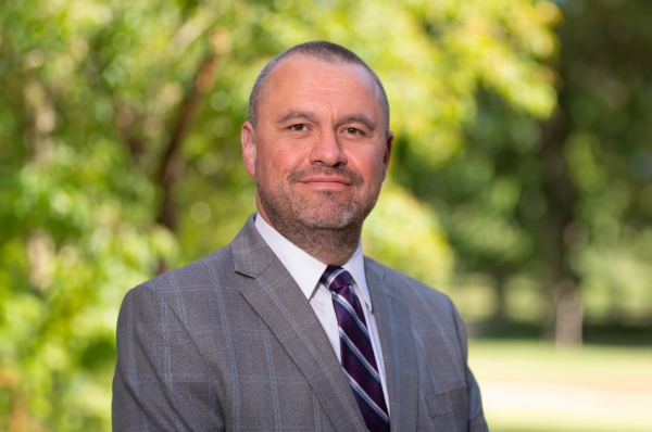 Kenneth Christensen, a light-skinned man with very short hair wearing a suit and tie