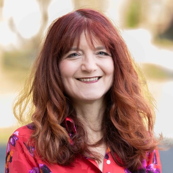 Patrice Torcivia Prusko, a light-skinned woman with reddish hair, wearing a patterned red button-up blouse.