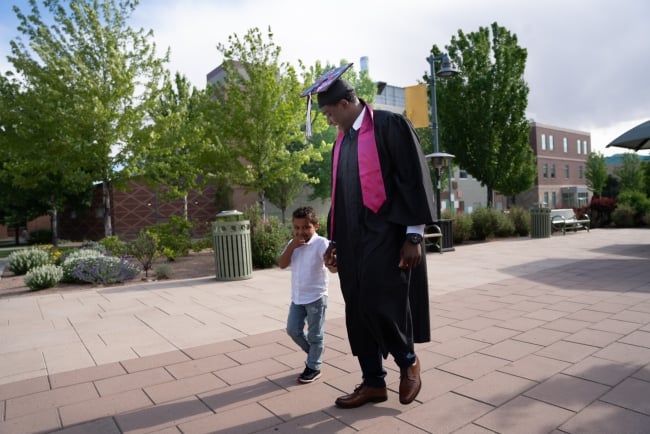 African American Male Graduate Standing Outside College Stock