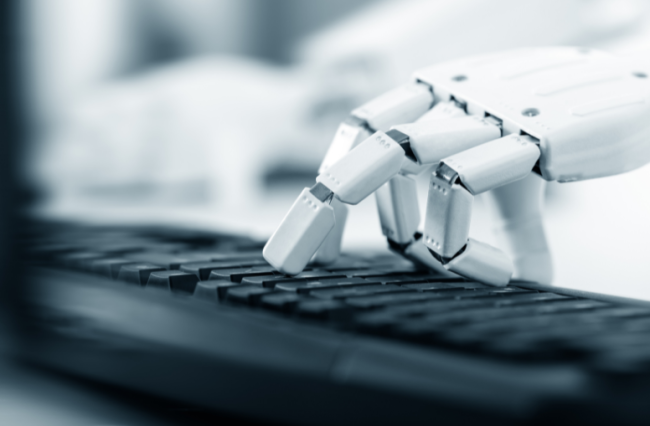 A robotic hand types on a keyboard.