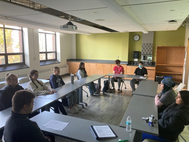 A group of Le Moyne students sit at desks