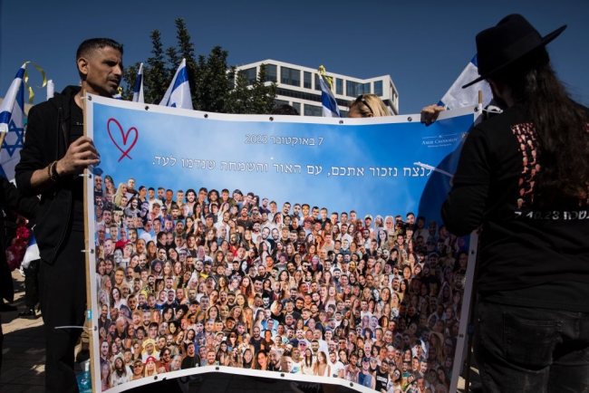 Two people hold a placard with photos of people killed during the Oct. 7 Hamas attack.