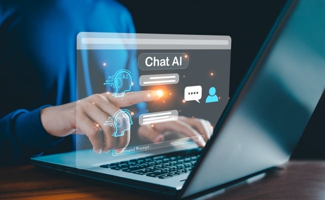 A close-up of human hands resting on a laptop running a chat AI software.