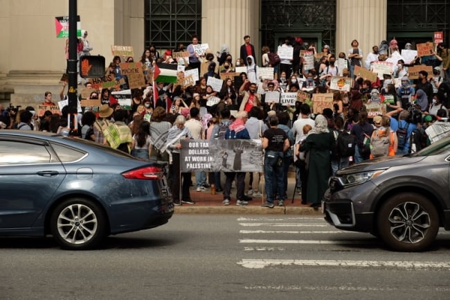 A group of protesters gather outside a building at MIT.