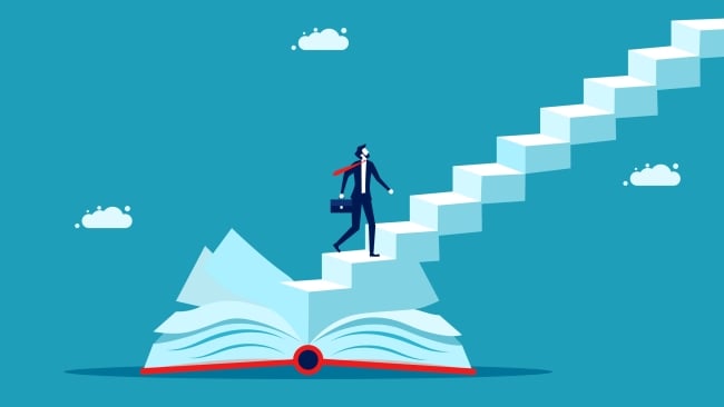 Man holding briefcases looks up long stairway emerging from a book as if wondering how to get to the top