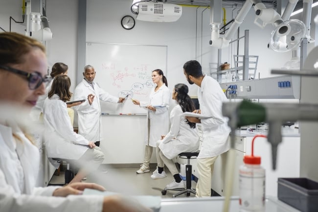 Students in a lab learning from professors.