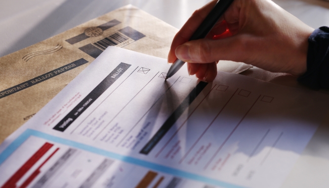 Stock photo of a voter filling out a ballot.