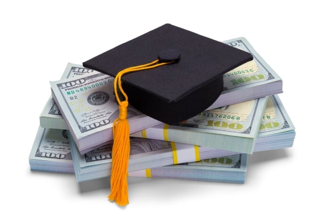 graduation mortar board on top of pile of cash