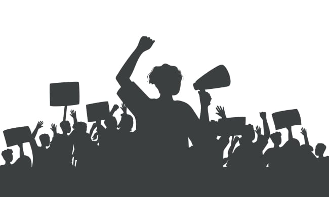 A silhouette of protesters against a white background. The figure in the front of the image has an arm raised and is obviously shouting into a bullhorn. Behind this figure, other protesters hold signs in the air.