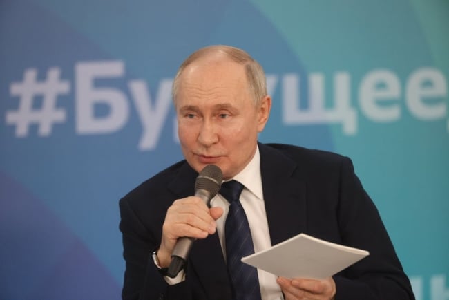 A picture of Russian President Vladimir Putin speaking into a microphone.