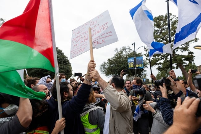 Students protesting at UCLA. One holds a Palestinian flag and one holds an Israeli flag. 
