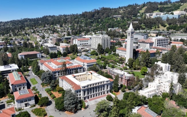 An aerial drone view of the University of California, Berkeley campus shows buildings and trees near a hillside