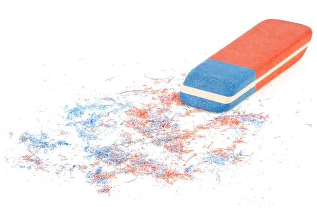 blue and orange eraser with shavings as if something has been rubbed out, like a letter or two